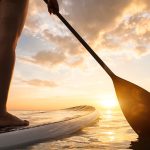 Stand Up Paddle Boarding On Quiet Sea Legs Close Up Sunset